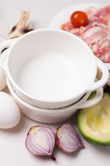 breakfast ingredients: eggs and vegetables, bacon on a white background