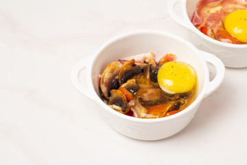 fried eggs with mushrooms and tomatoes, bacon on a white background