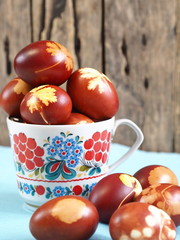 Easter. Coloring eggs for Easter onion peel. The traditional method of natural coloring. Eggs in a rustic colorful glass on a wooden background.