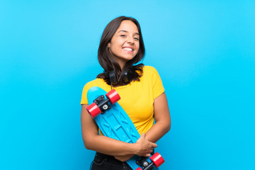 Young skater woman over isolated blue background