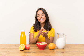 Young brunette girl having breakfast milk applauding