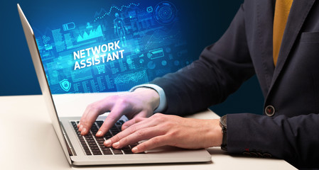 Obraz na płótnie Canvas Businessman working on laptop with NETWORK ASSISTANT inscription, cyber technology concept