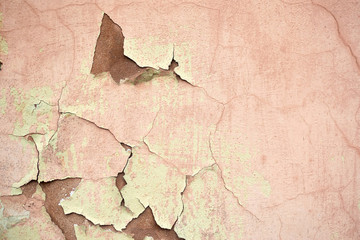 Concrete painted wall with falling cracked paint.