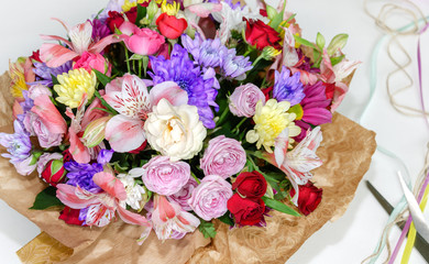 beautiful bouquet with different flowers, roses and chrysanthemums, scissors and thread