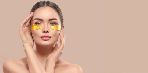 Woman with under eye collagen gold pads, beauty model girl face with healthy fresh skin. Skin care...