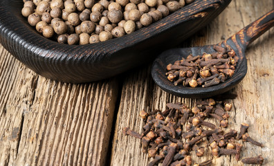 Wooden spoon with cloves on rustic table