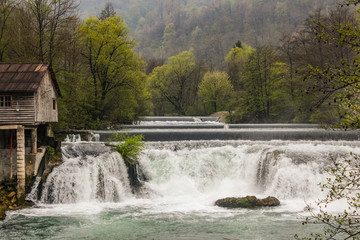 Layered waterfall on the river Una in Bosnia-Herzegovina with a lot of water vapor in the early morning.Dramatic shot of a layered waterfall on the river Una in Bosnia-Herzegovina