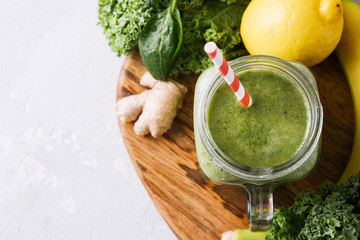 Freshly prepared jar of green smoothie, close up. Fresh vegetable smoothie on a light background. Vegetable smoothie with spinach and kale cabbage.