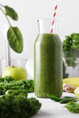 Freshly made bottle of green smoothie, close-up. Fresh vegetable smoothie on a light background. Vegetable smoothie with spinach and kale cabbage.