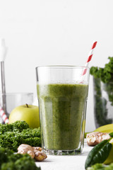 Freshly prepared glass of green smoothie, close-up. Fresh vegetable smoothie on a light background. Vegetable smoothie with spinach and kale cabbage.