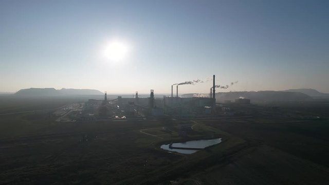 Potash plant for the extraction of potash fertilizers, mountains of waste near the plant, smoke from pipes, shooting from a height