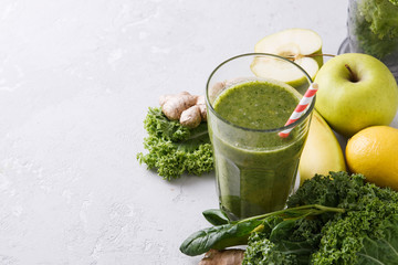 Freshly prepared glass of green smoothie, close-up. Fresh vegetable smoothie on a light background. Vegetable smoothie with spinach and kale cabbage.