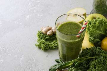 Freshly prepared glass of green smoothie, close-up. Fresh vegetable smoothie on a light background. Vegetable smoothie with spinach and kale cabbage.