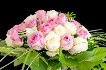 Kugeliger Rosentstrauß in den Farben weiß und rosa isoliert auf schwarzem Hintergrund mit Platz für Text