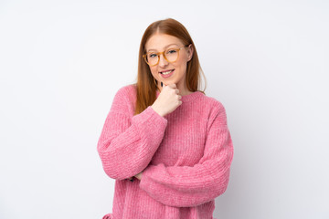 Young redhead woman with pink sweater over isolated white background with glasses and smiling