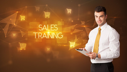 Businessman with shopping cart icons and SALES TRAINING inscription, online shopping concept