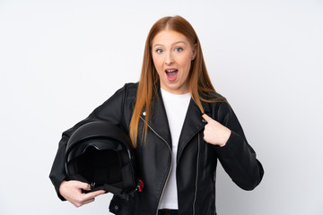 Young redhead woman with a motorcycle helmet over isolated white background with surprise facial expression