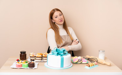 Obraz na płótnie Canvas Young redhead woman with a big cake laughing