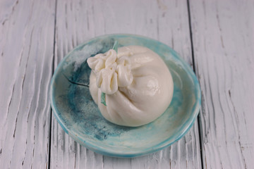 Burrata cheese bag on wooden background