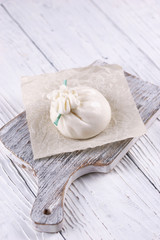 Burrata cheese bag on wooden background