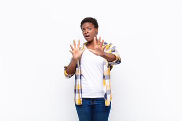 young pretty black womanfeeling terrified, backing off and screaming in horror and panic, reacting...