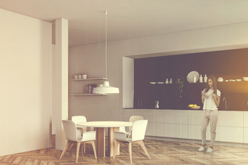 Woman with coffee in white and black kitchen