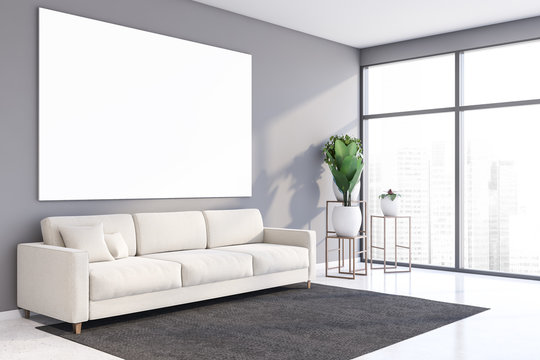 Gray living room corner with sofa and poster
