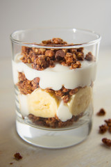 Food photography of a banana parfait with chocolate granola.