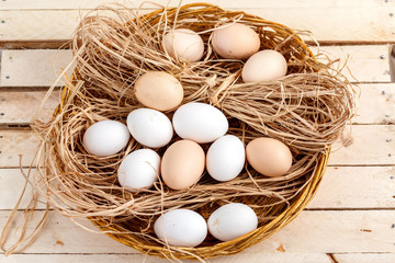 raw eggs in the hay on a wooden background