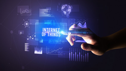 Hand touching INTERNET OF THINGS inscription, new business technology concept
