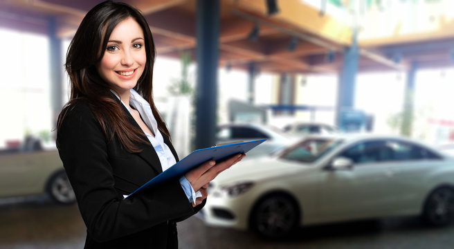 Saleswoman with folder and auto show background