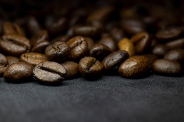Coffee in beans on dark background. Abstract background texture.Coffee beans texture. Food background of coffee beans