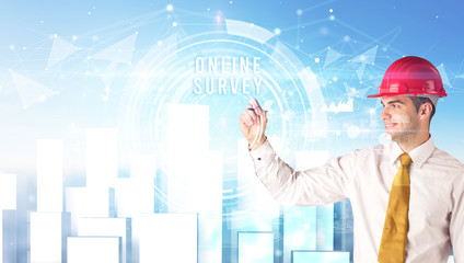 Handsome businessman with helmet drawing ONLINE SURVEY inscription, contruction business concept