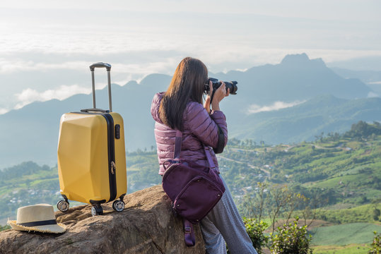 Traveller woman with suitcase take a photo on vacation. 