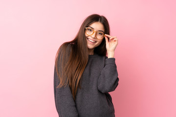 Young woman over isolated pink background with glasses and happy