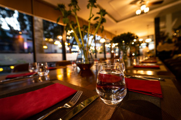 Glass of water on the table with knife and tablecloth inside a restaurant - Restaurant interior with luxury decoration