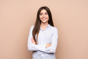 Young woman over isolated background keeping the arms crossed in frontal position