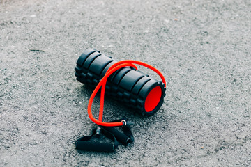 black and red sports roller and elastic band lie on the ground