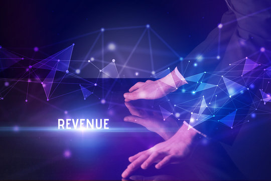 Businessman touching huge screen with REVENUE inscription, modern technology business concept