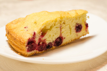 A piece of homemade cherry pie is on a white plate. Close up. Selective focus.