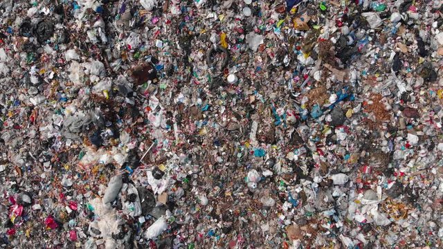 Aerial view of waste garbage dump household pile plastic trash. Burning dump site, smoke clouds, air pollution. Concept environmental struggle with plastic industry.
