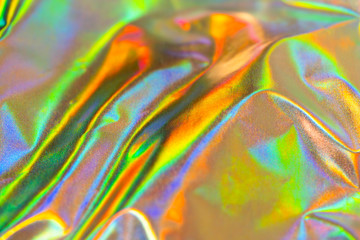 Iridescent fabric trendy holographic background. Colorful chrome fabric. Yellow green red blue