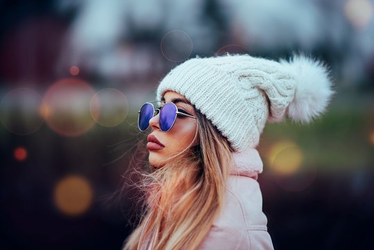 Side View Of Woman Wearing Sunglasses And Knit Hat