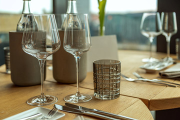 A festively set table in a restaurant. Focus on the glasses. Concept: decoration or food and drink