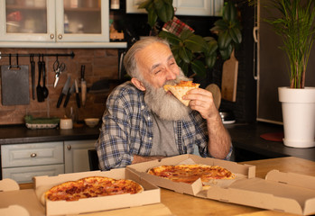 Close-up view of happy bearded senior man eating pizza