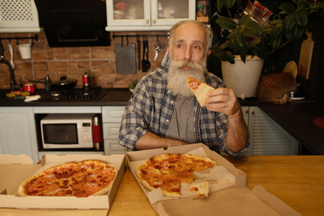 Close-up view of happy bearded senior man eating pizza