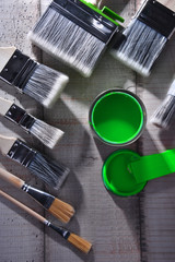 Paintbrushes of different size and paint can