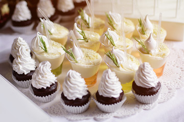 Table with cupcakes and different sweets for party. Candy bar.
