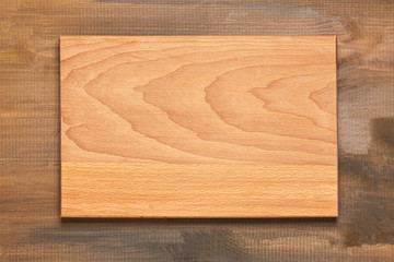 Top view of wooden cutting board on background. Close up.