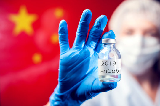 A doctor in blue medical gloves and mask holding an ampula with vaccine in front of flag of China. Close up shot. Coronavirus, epidemic and medicine concept.